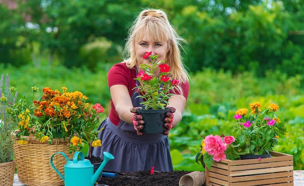 Uma mulher está plantando flores no jardim Foco seletivo