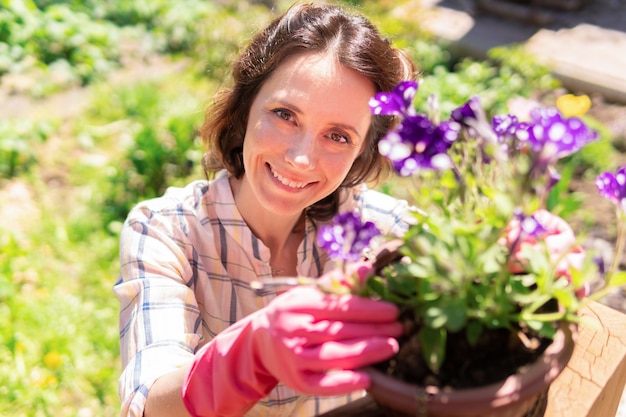 Uma mulher está plantando plantas e flores em seu quintal.