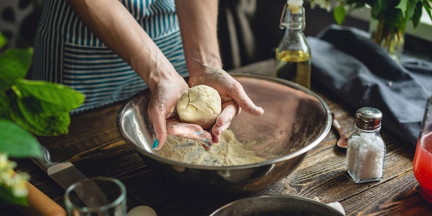 Uma mulher está preparando massa fresca em um ambiente aconchegante