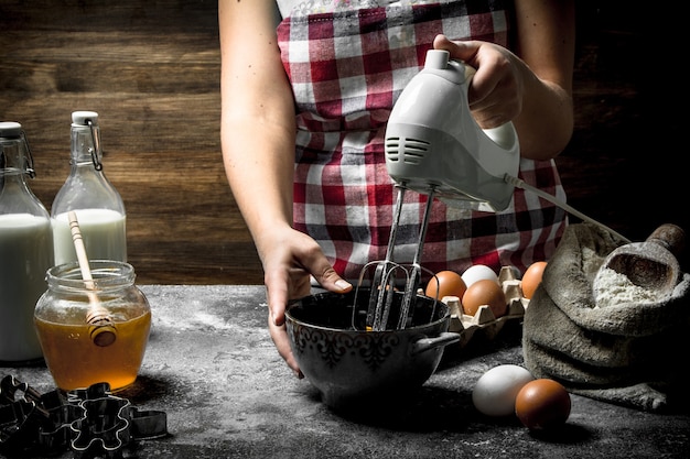 Uma mulher está preparando uma massa fresca. sobre uma superfície rústica.