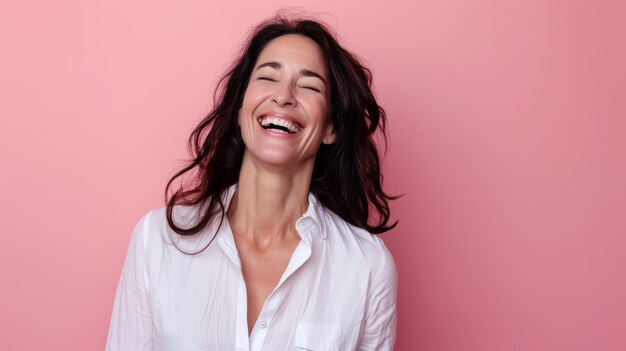 Foto uma mulher está rindo e sorrindo na frente de um fundo rosa