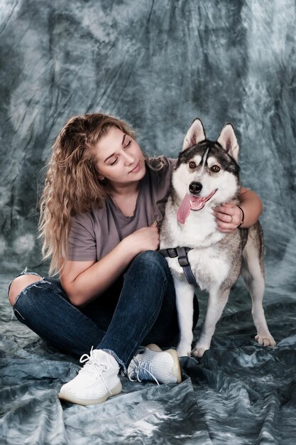 Foto uma mulher está sentada com um cachorro husky