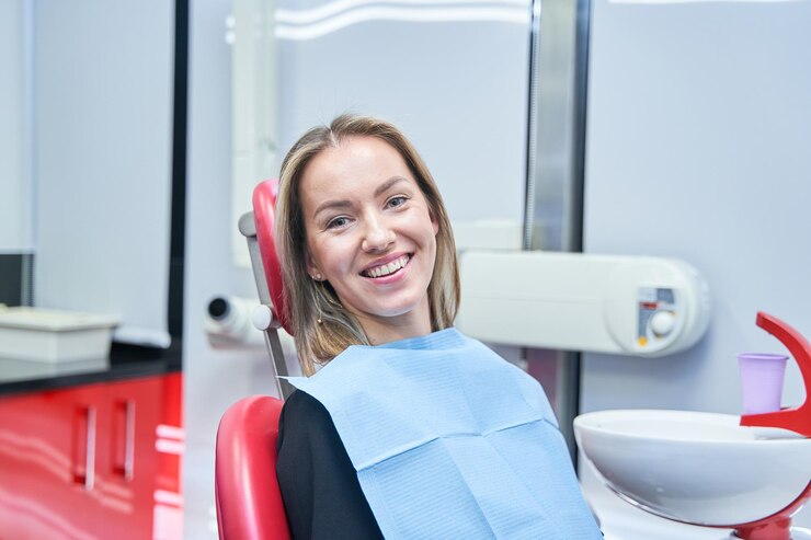 Foto uma mulher está sentada em uma cadeira de dentista com um sorriso no rosto