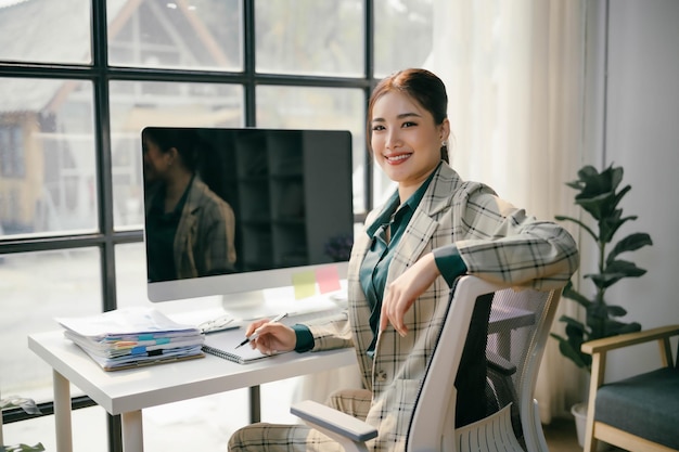 Foto uma mulher está sentada em uma mesa com um monitor de computador na frente dela