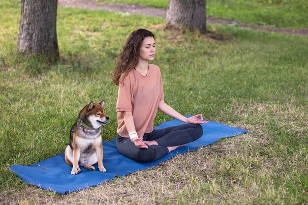 Uma mulher européia esportiva pratica ioga e meditação em um parque ou lugar público; uma mulher pratica esportes