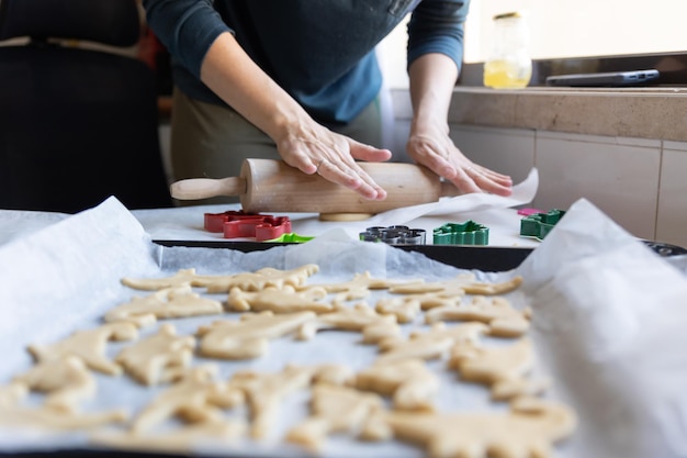 Uma mulher fazendo biscoitos em forma de dinossauros