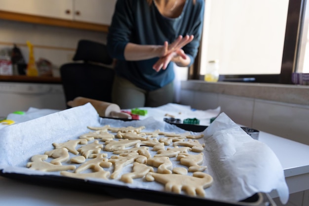 Uma mulher fazendo biscoitos em forma de dinossauros