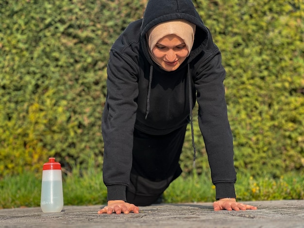 Uma mulher fazendo flexões com uma garrafa de água
