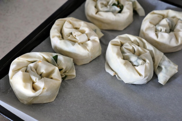 Uma mulher fazendo massa de espinafre e queijo com massa fina