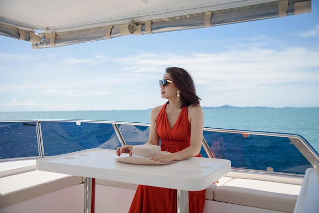 Uma mulher feliz está relaxada no iate durante sua viagem de férias