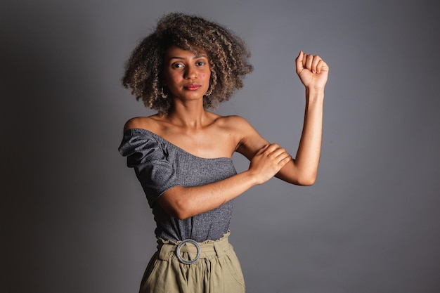 Uma mulher flexiona o braço e flexiona o braço.