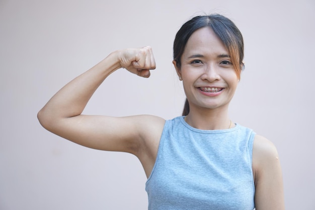Uma mulher flexiona seus músculos mostrando sua força