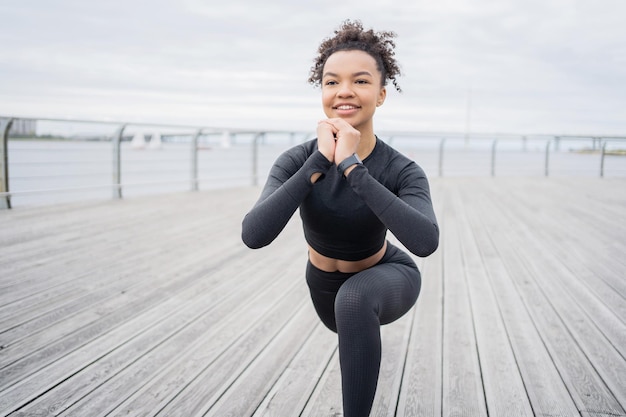 Uma mulher forte e atlética faz um treino com um relógio rastreador de pulseira de fitness no braço