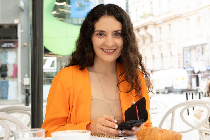 Foto uma mulher freelancer trabalha sentada em um café com um telefone nas mãos e um caderno em sua mesa