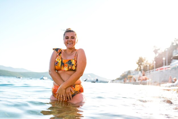 Uma mulher gorda gosta do mar ao pôr do sol. Foco seletivo. foto de alta qualidade