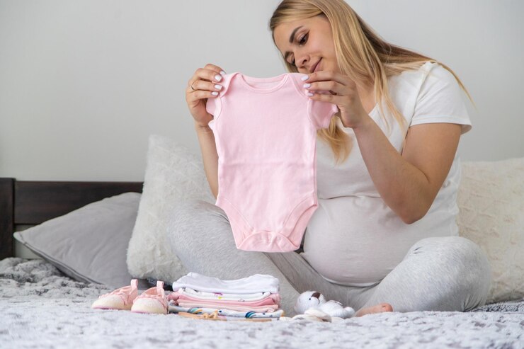 Uma mulher grávida coleciona coisas de bebê Foco seletivo