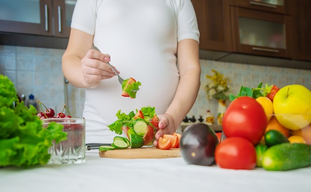 Uma mulher grávida come legumes e frutas