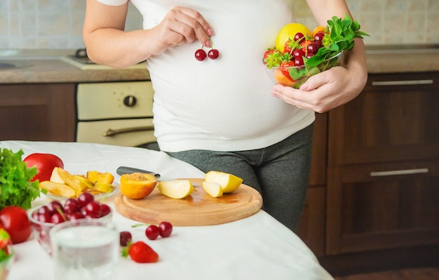 Uma mulher grávida come legumes e frutas