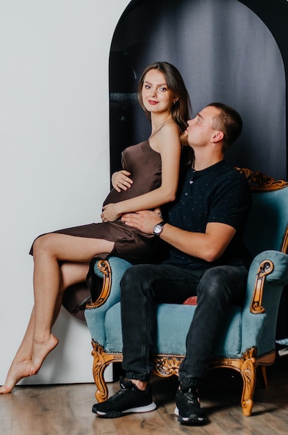 uma mulher grávida e um homem estão sentados em uma cadeira