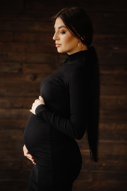 Foto uma mulher grávida está em frente a uma parede de madeira