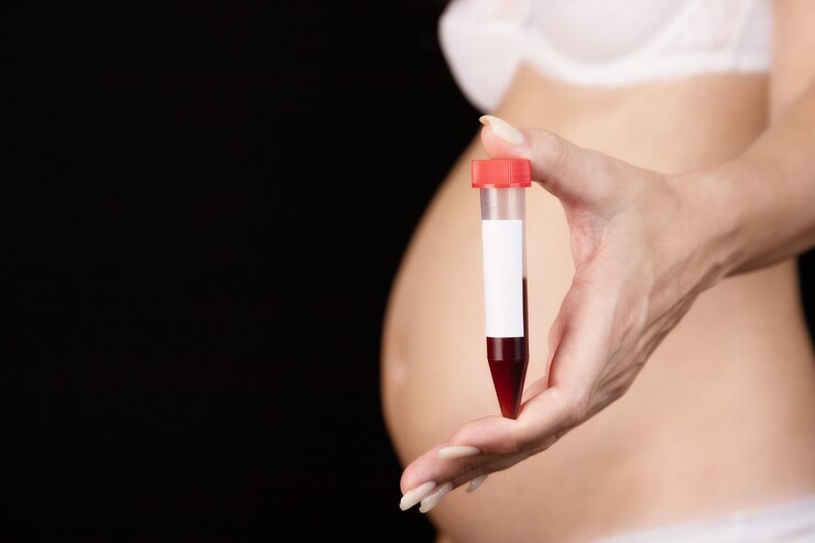 Foto uma mulher grávida segura um tubo de ensaio com sangue na frente dela. gravidez, controle de sangue em laboratório.