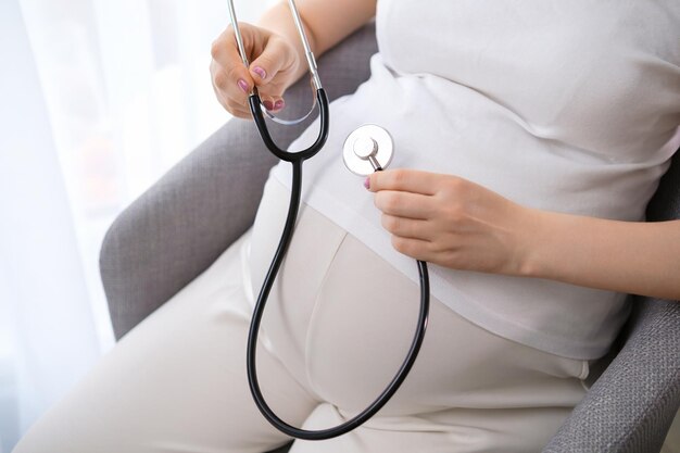 Uma mulher grávida usa um estetoscópio