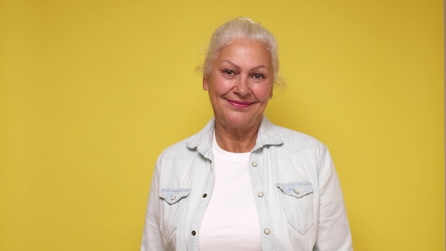 Foto uma mulher idosa europeia de óculos olha com confiança para a câmera sorrindo