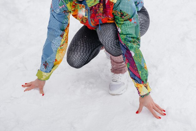 Uma mulher jovem e bonita está correndo em um dia gelado e com neve. Esportes, estilo de vida saudável