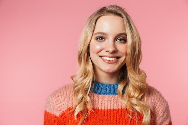 uma mulher jovem e bonita feliz, animada, posando isolada sobre uma parede rosa