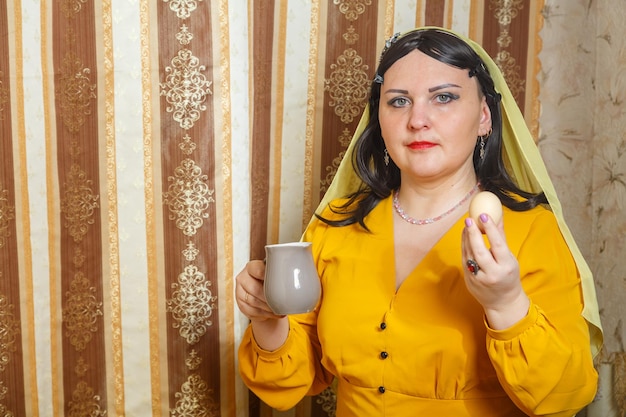 Uma mulher judia de peruca e cobertura de cabeça em casa à mesa no seder da páscoa