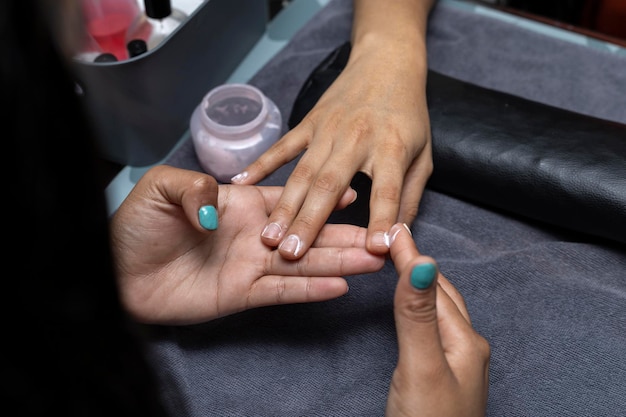 Uma mulher latino-americana recebe um tratamento de manicure em um salão de beleza
