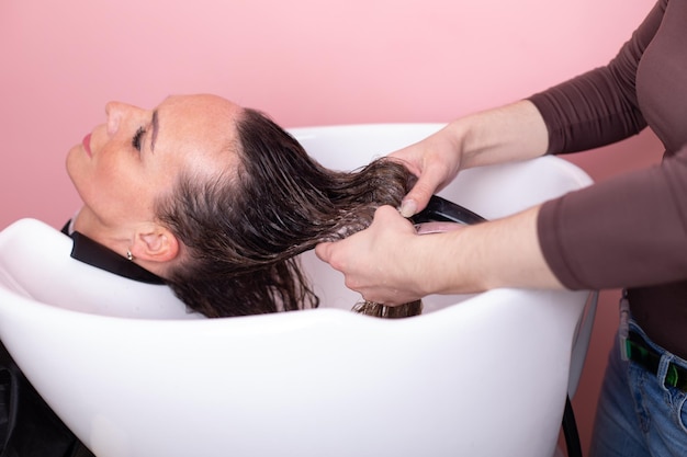 Uma mulher lavando o cabelo em uma banheira