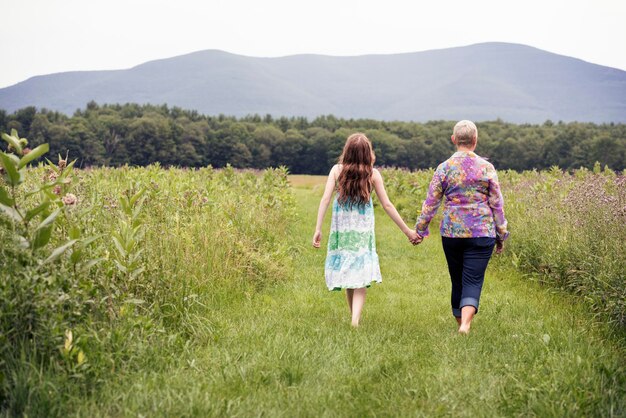 Uma mulher madura e uma jovem em um prado de flores silvestres