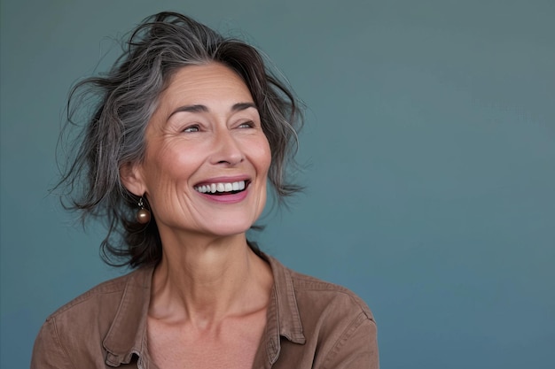 Uma mulher mais velha sorrindo e olhando para a câmera