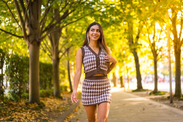 Uma mulher morena caucasiana no outono caminhando por um parque natural no estilo de vida do outono da cidade