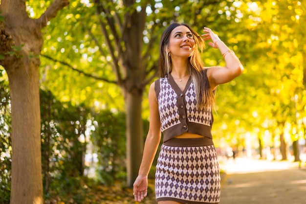 Uma mulher morena caucasiana no outono caminhando por um parque natural no estilo de vida do outono da cidade