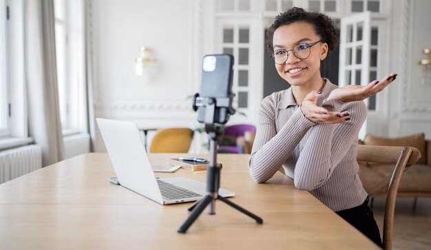 Uma mulher na comunicação on-line do bate-papo por vídeo do escritório usa um laptop