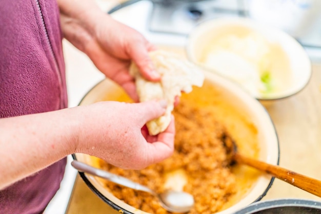 Uma mulher na cozinha prepara um prato de Golubtsi