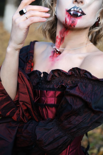 Uma mulher na imagem de um vampiro ou bruxa com maquiagem branca e vestido medieval