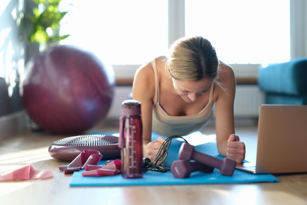 Uma mulher no chão faz um exercício de prancha