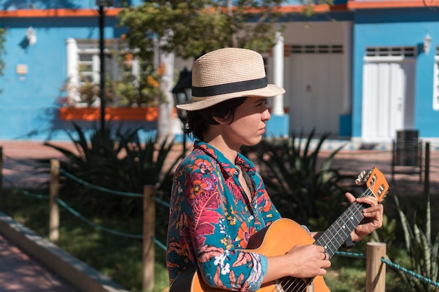 Uma mulher no parque tocando violão