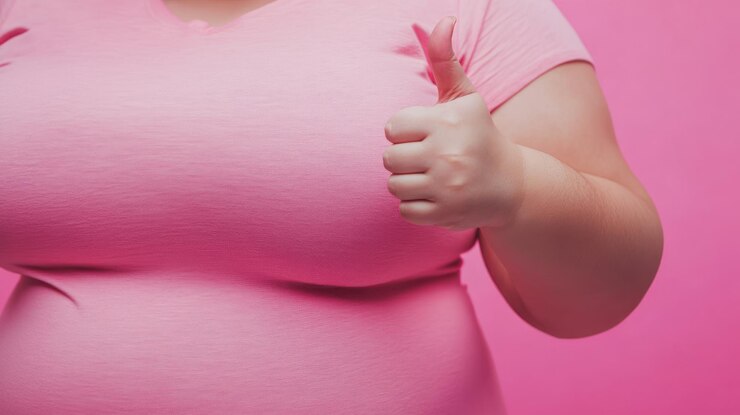 Foto uma mulher obesa com uma camisa rosa está dando um polegar para cima