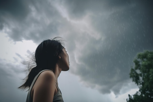 Uma mulher olha para o céu e a chuva está caindo.