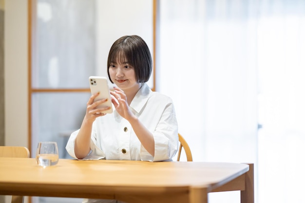 Uma mulher operando um smartphone na sala