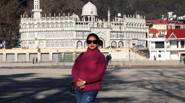 Uma mulher posa em frente a um prédio na cidade de udaipur.