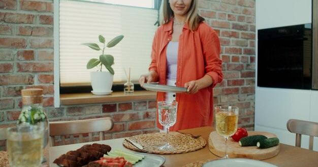 Uma mulher prepara a mesa para o jantar.