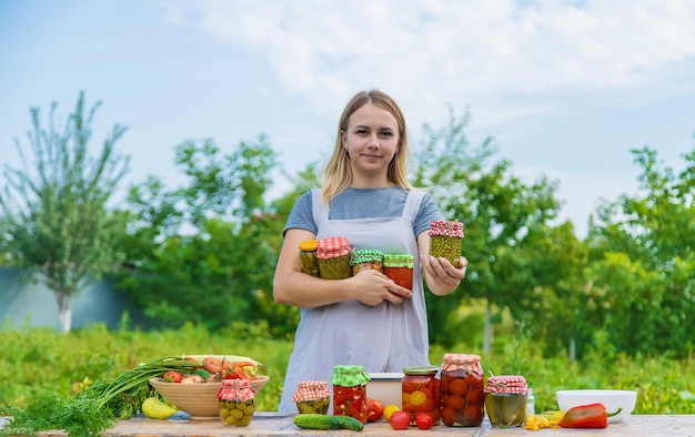 Uma mulher preserva legumes em potes foco seletivo