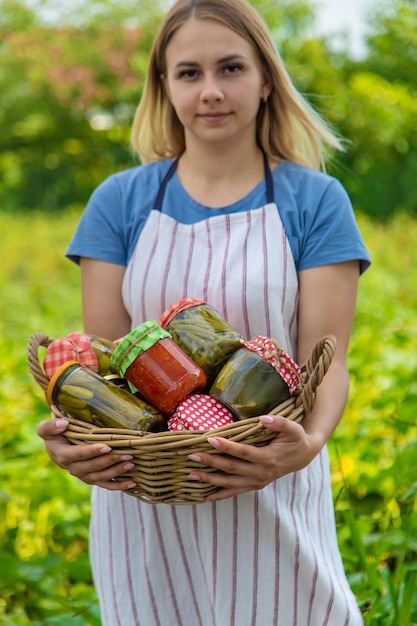 Uma mulher preserva legumes em potes Foco seletivo