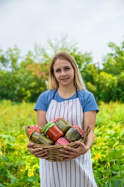 Uma mulher preserva legumes em potes foco seletivo