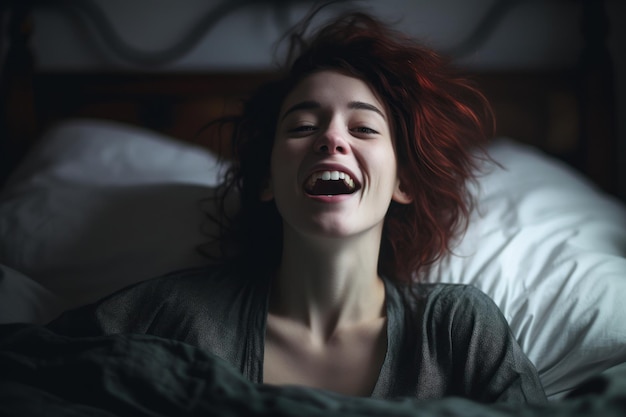 Uma mulher ruiva está rindo em uma cama.